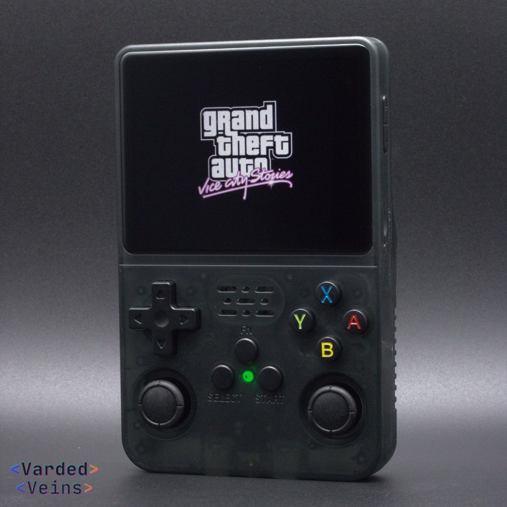 Black handheld gaming console with 'Grand Theft Auto Vice City Stories' on screen against a dark background