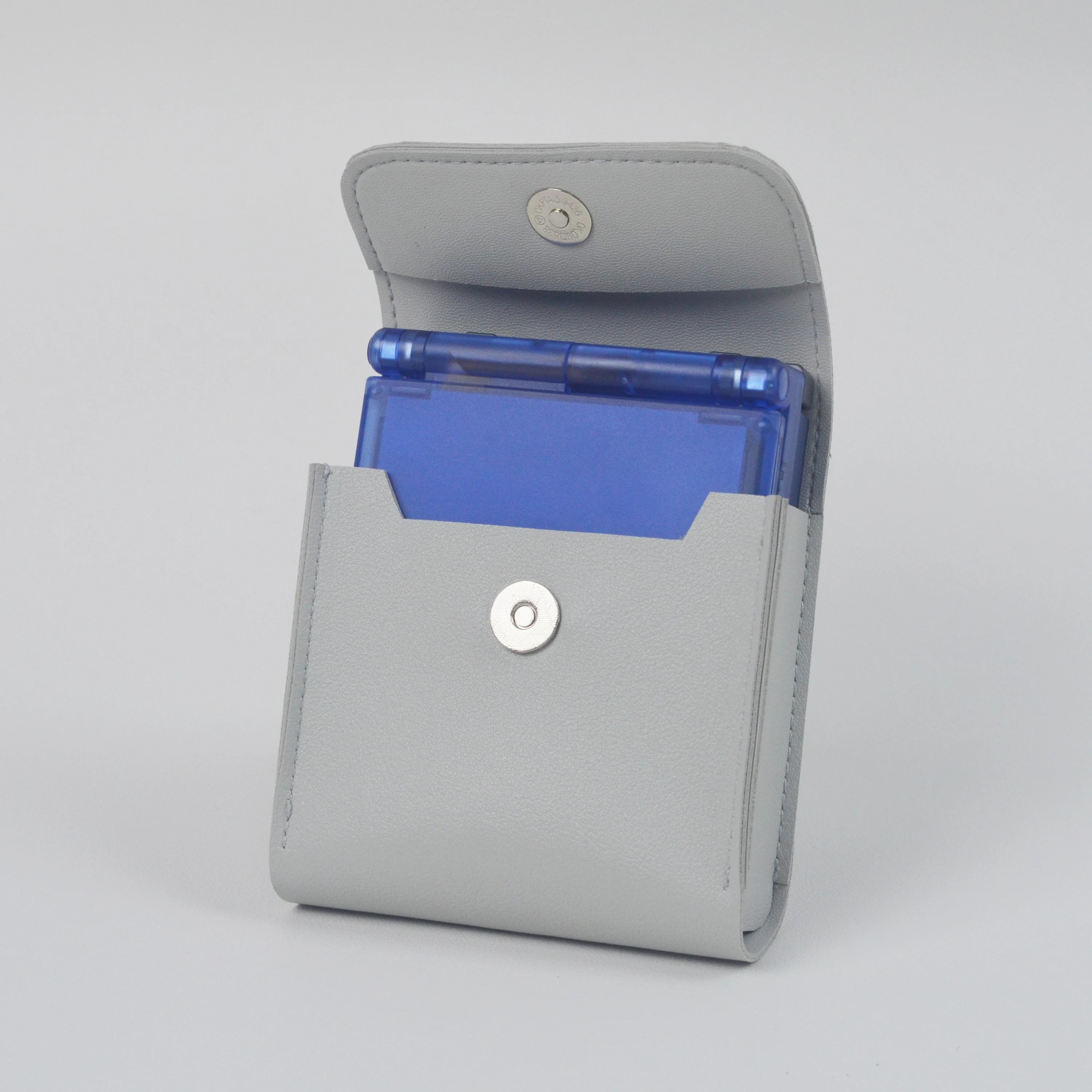 Gray handheld console case with a blue card inside on a white background